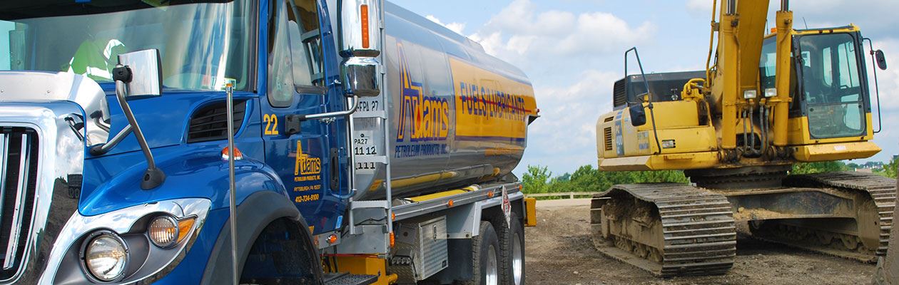 Adams Petroleum fueling truck next to bulldozer.