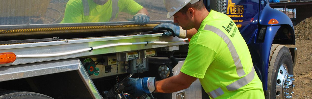 Employee of Adams Petroleum fueling an Adams Petroleum truck.