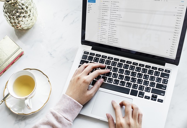 woman's hands on keyboard reading email