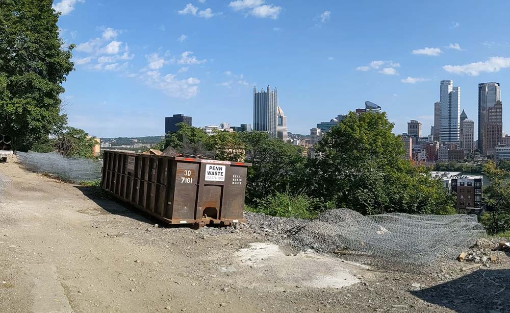 Penn Waste dumpster overlooking City of Pittsburgh skyline