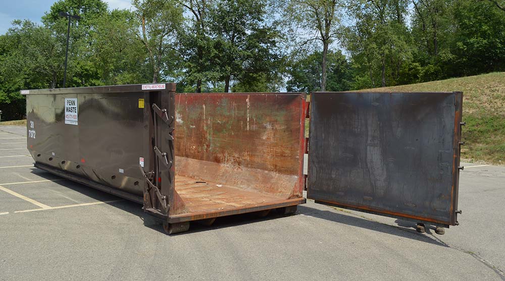 Penn Waste dumpster rear door open in parking lot 