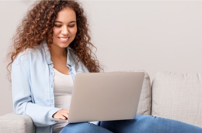 young woman using laptop from a couch
