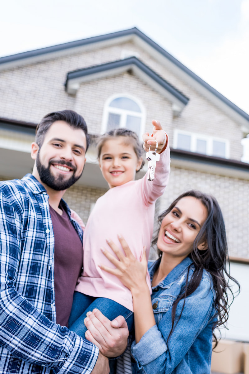 young family with keys to their first home