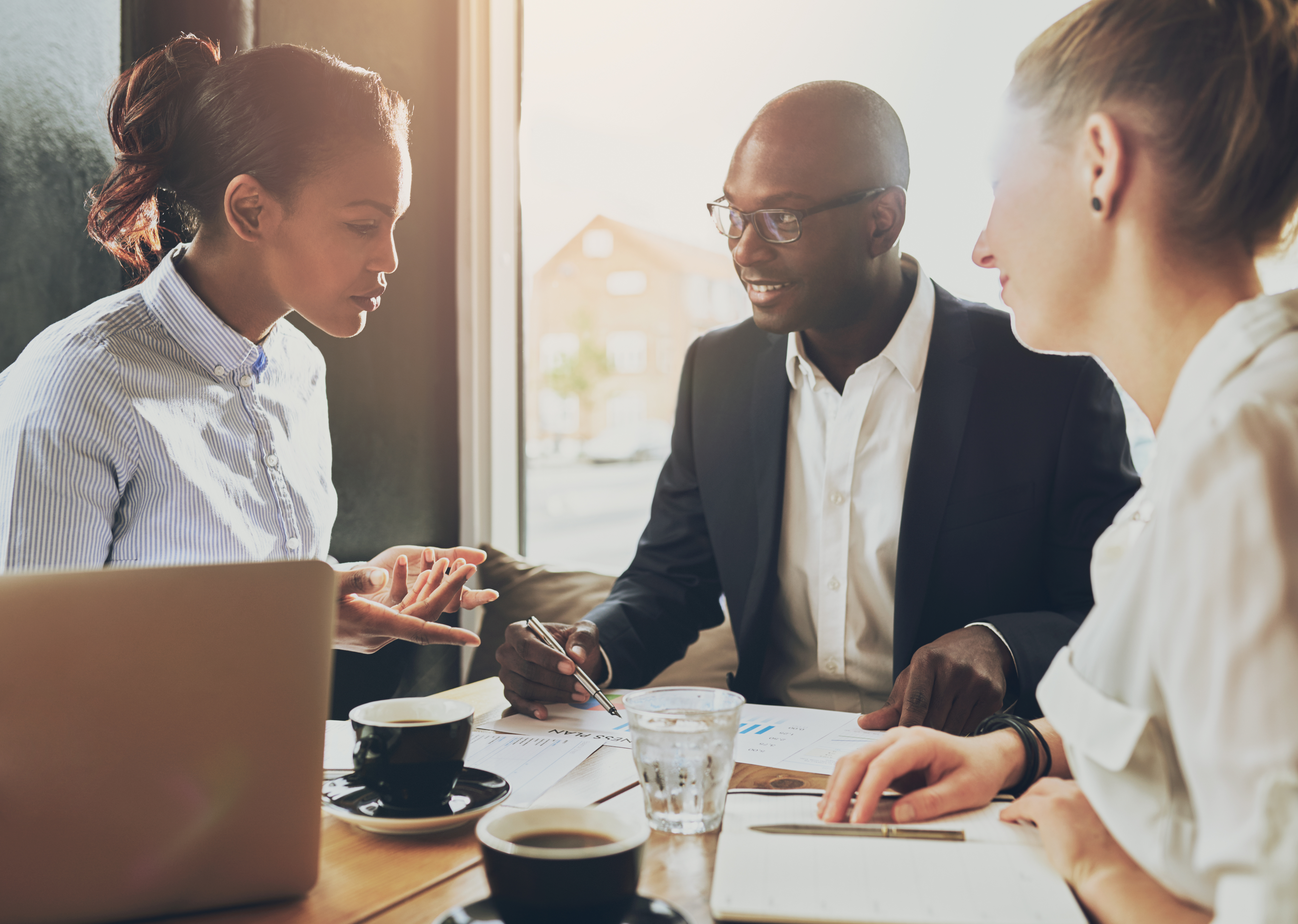 A group of young professionals sitting at a table discussing business matters.