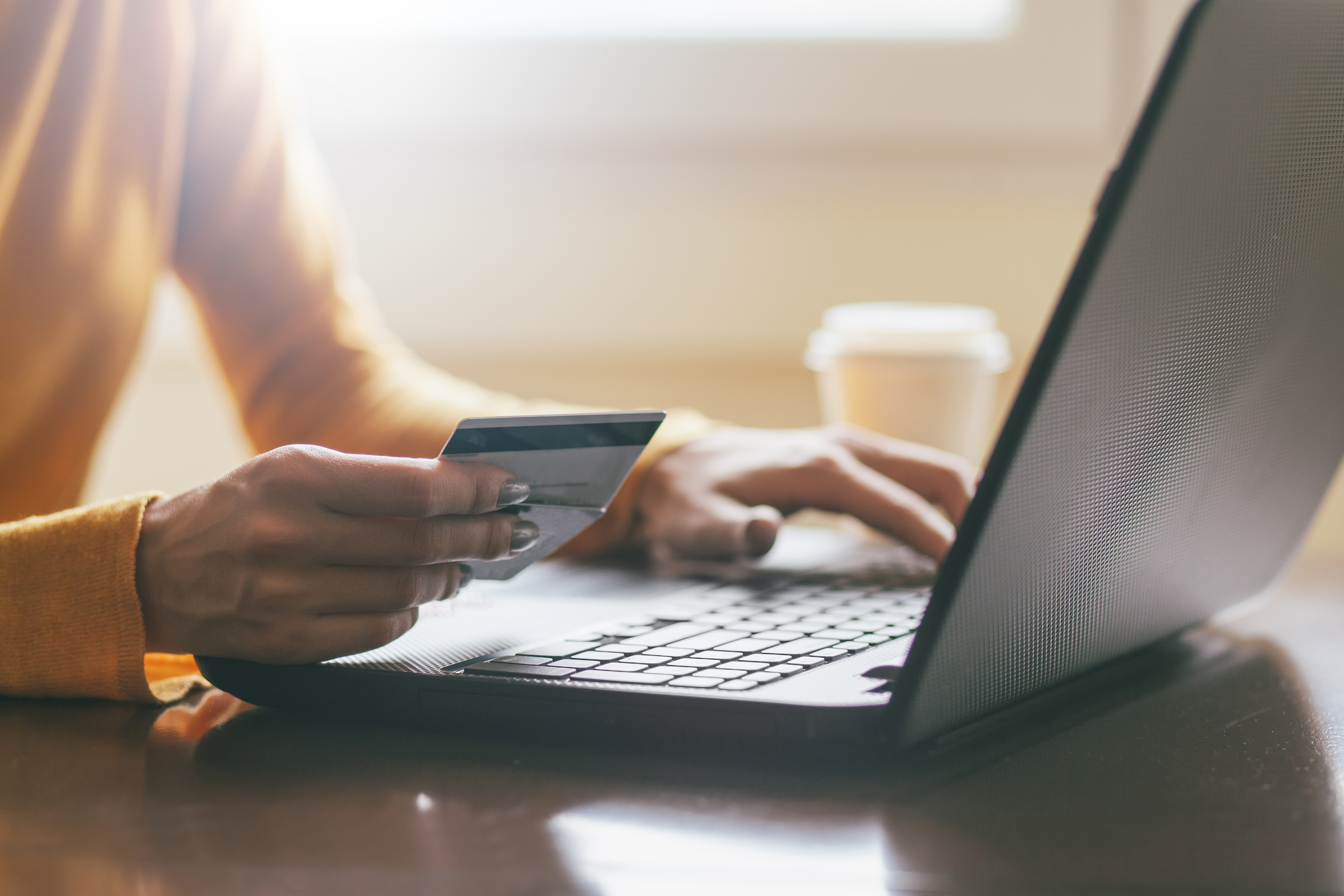 woman holding credit cards with hands on keyboard