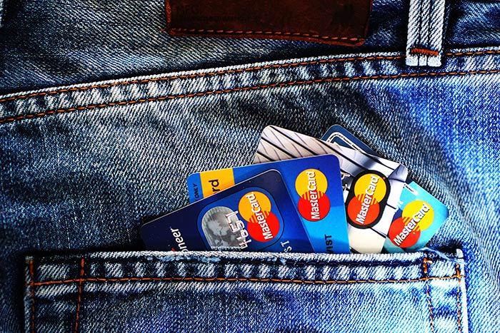 Group of credit cards lining the back pocket of a pair of jeans.