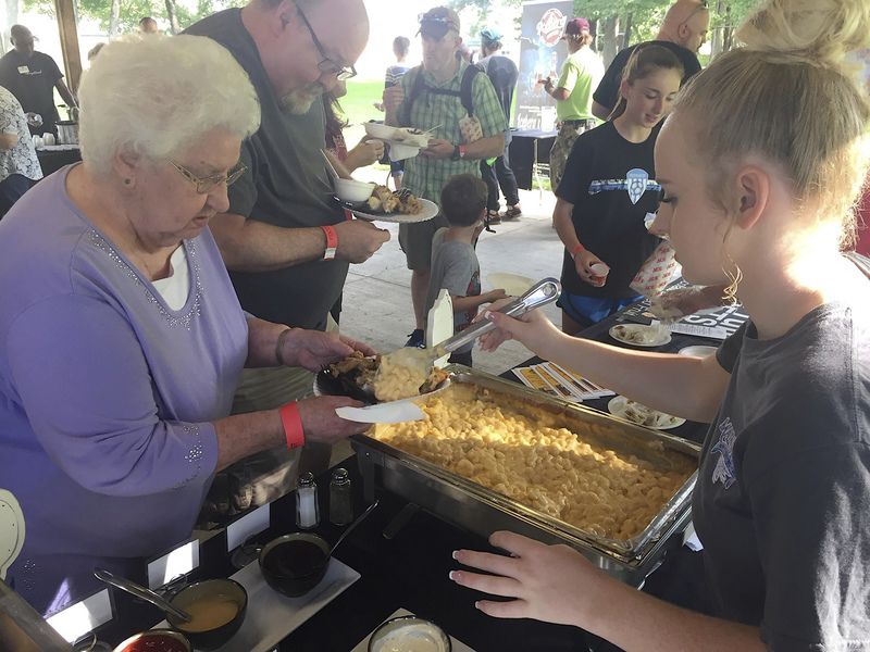 Young girl serving a woman food at the sixth annual Foodie Fest in Grove City.