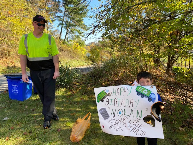 nolan holding sign next to valley waste employee