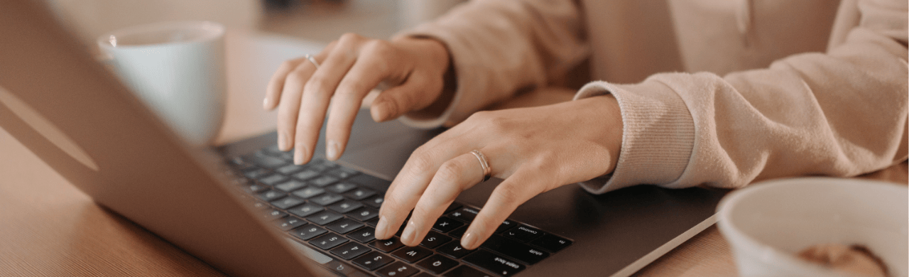 closeup of hands typing on a laptop