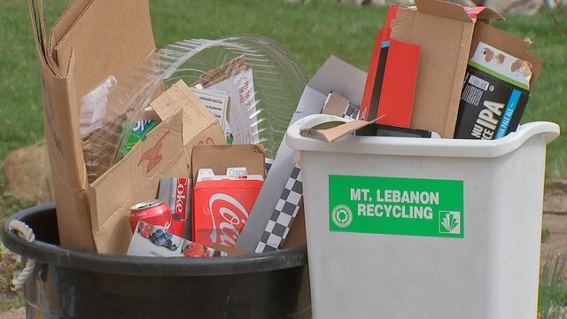 recycling bins filled with cardboard, plastic, and aluminum cans